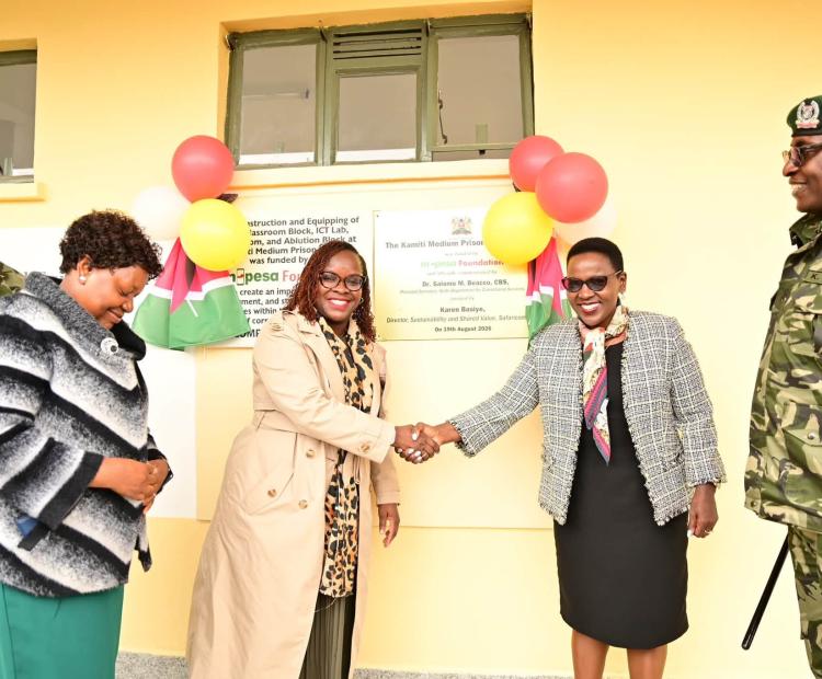Correctional Services Principal Secretary (PS), Dr. Salome Beacco (Second Right), shares a handshake with M-Pesa Foundation Executive Director, Karen Basiye, as Commissioner General of Prisons Patrick Aranduh (Far Right), looks on during launch of the new tuition block at the Kamiti Medium Security Prison